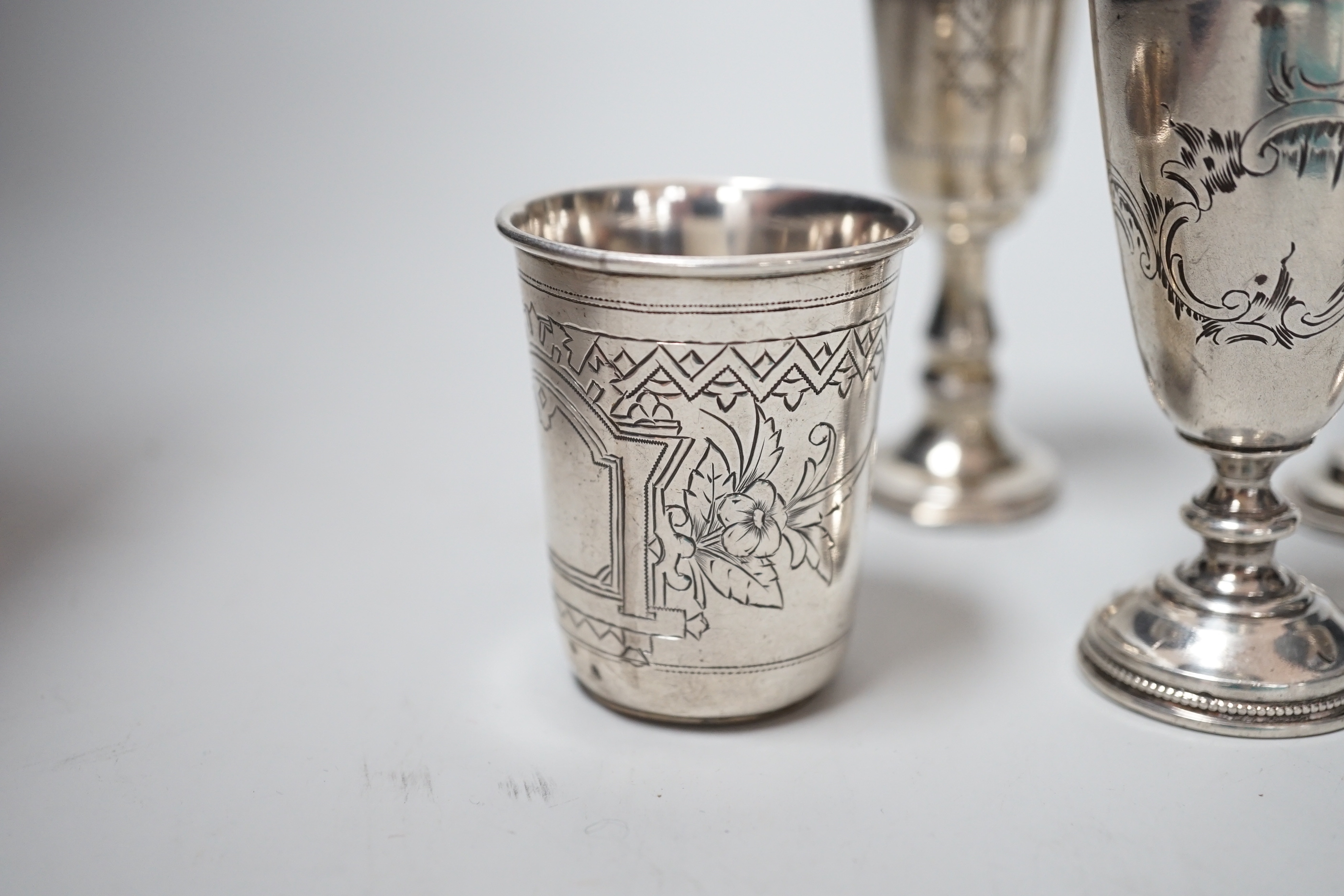 Two George V silver kiddush cups, 82mm, two Russian 84 zolotnik white metal pedestal tots and similar beaker, dated 1890, 4.6oz.